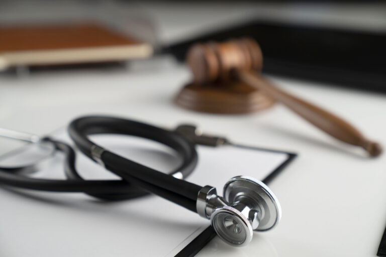 a stethoschope and a gavel on a white table